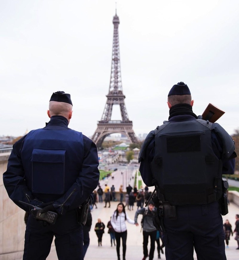 Two policemen, back, in front of the Eiffel Tower